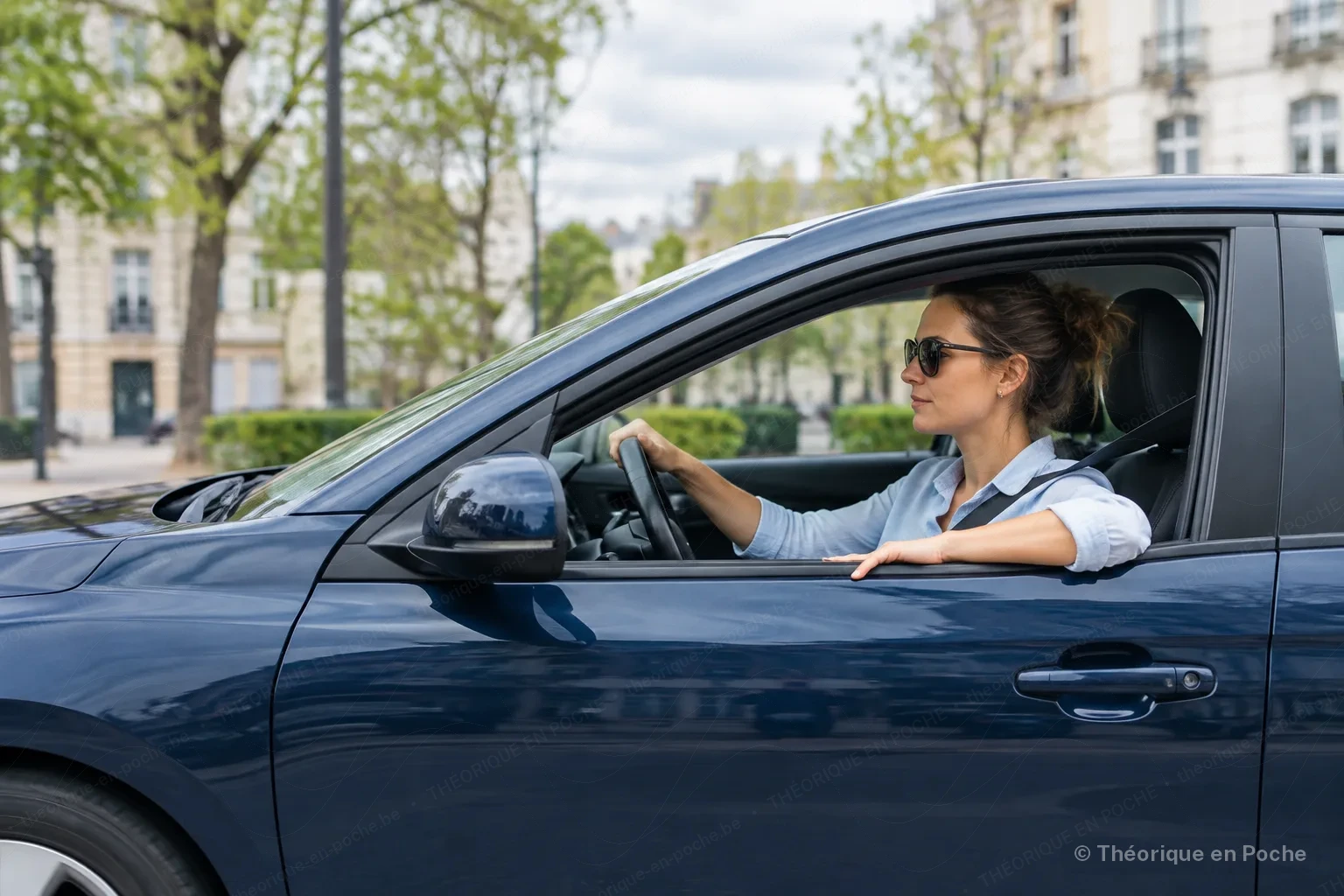 Image originale Tout pour mon permis (générée par IA, panneaux officiels) A woman in sunglasses drives a dark blue car in town, with the driver's window down, seatbelt fastened and one hand resting on the edge of the door.
